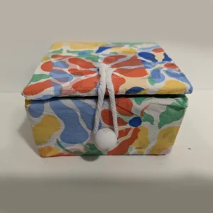 imagen de una cajita con tapa de cartón. Tono varios colores.