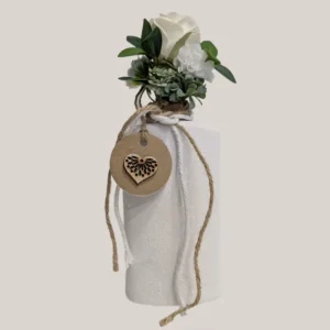 imagen de una botella de plastico con cuerda de algodón y flores artificiales. Tono blanco y verde.