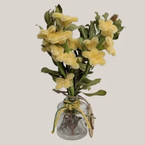 imagen de un florero de vidrio con cuerda de algodón y flores artificiales. Tono verde y amarillo.