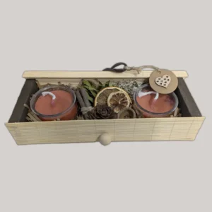 imagen de una caja con dos velas y decoración natural. Tono naranja