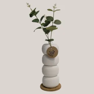 imagen de un florero con donuts de piscina decorado con pintura a la tiza y base de madera de bambú  - flores artificiales. Tono: blanco y verde.