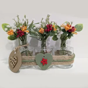 imagen de Envases de vidrio con flores artificiales. Tono rojo y naranja.